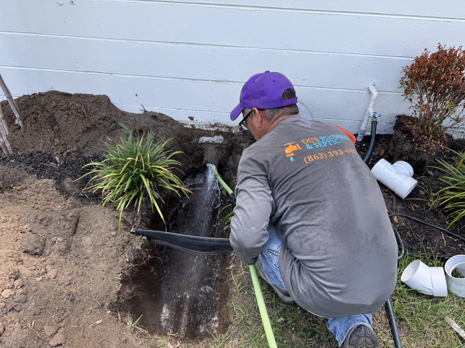 OC's Plumbing & Septic technician repairing exposed exterior plumbing at a Central Florida home